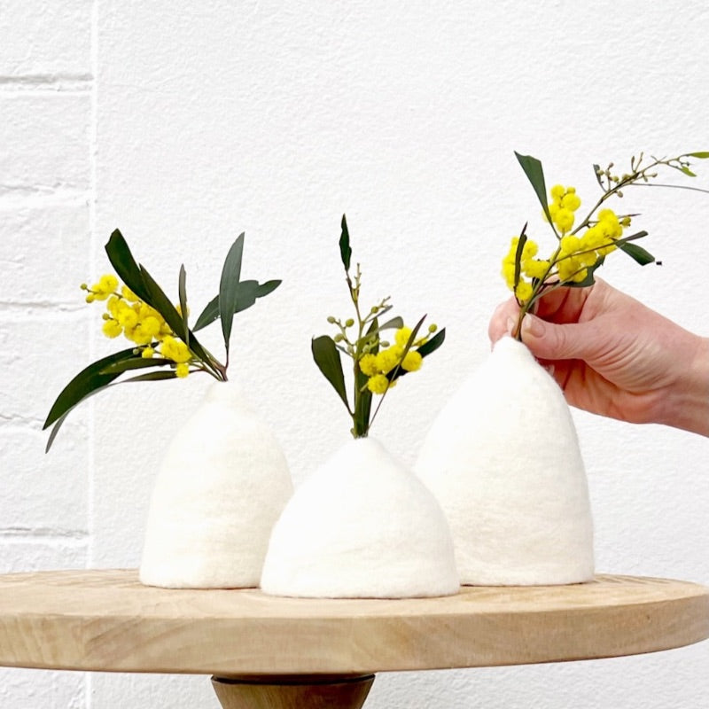 Three white Tinkerbell vases with yellow flowers