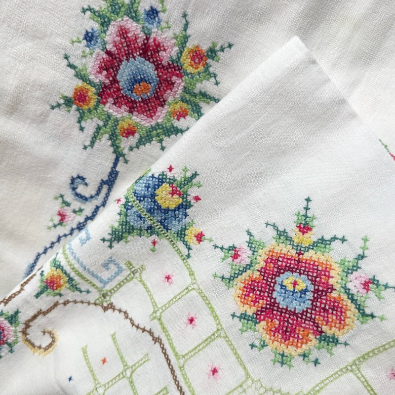 Intricate floral embroidery on linen fabric.