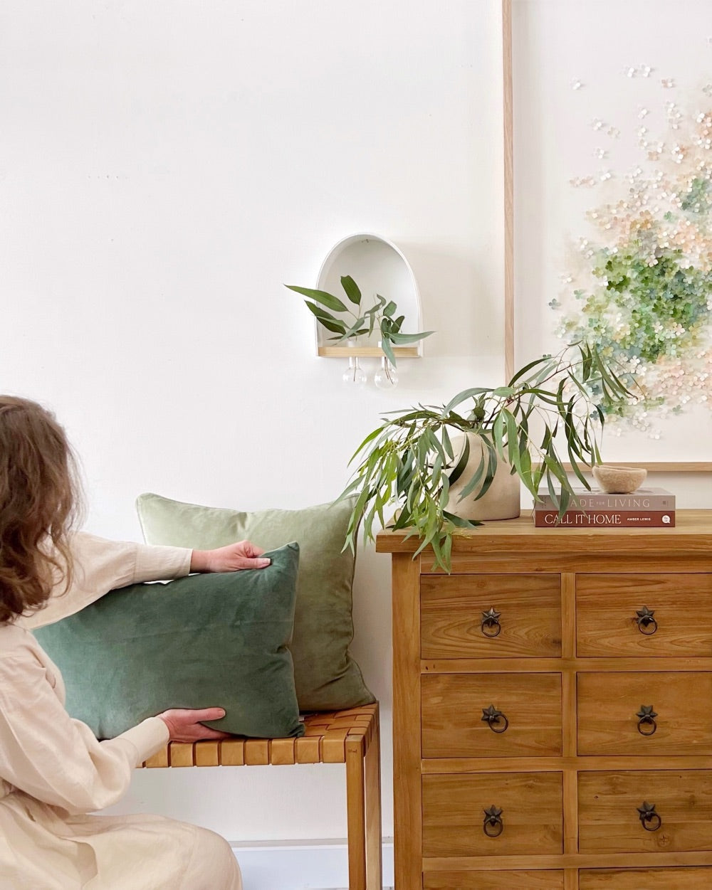 mondocherry arranging cushions and green artwork.