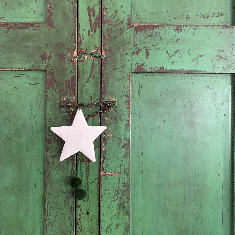 Weathered green door with white star decoration.