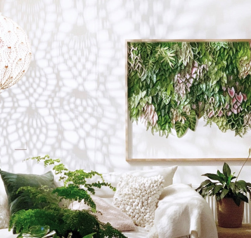 Interior with mondocherry wall art, white sofa and green cushions.
