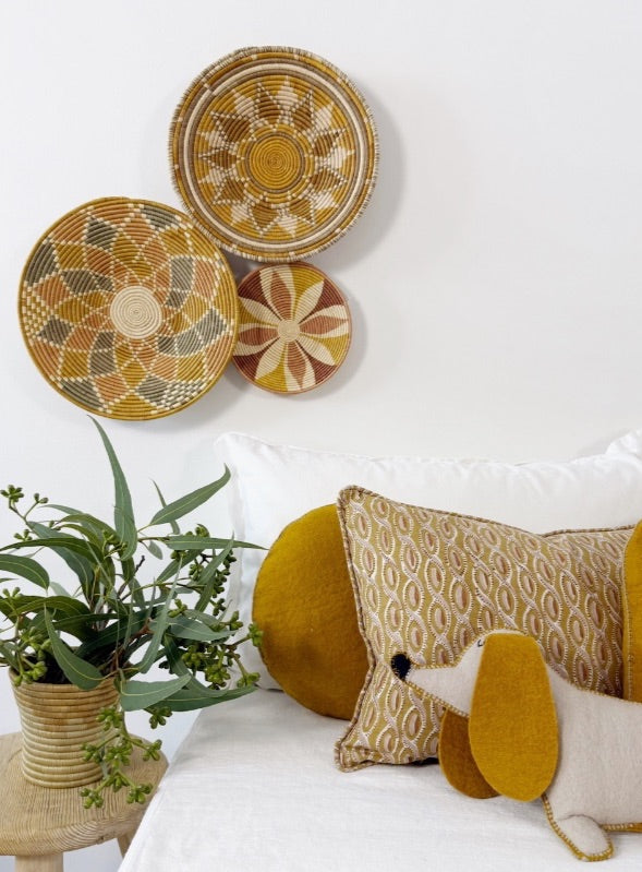 Decorative pillows and wall baskets in cozy room.