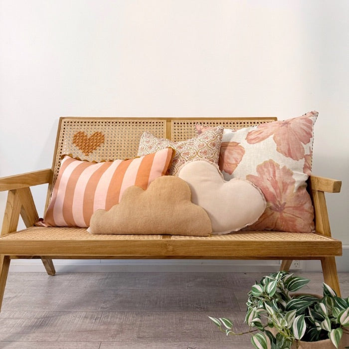 Wooden bench with patterned and plain pillows.