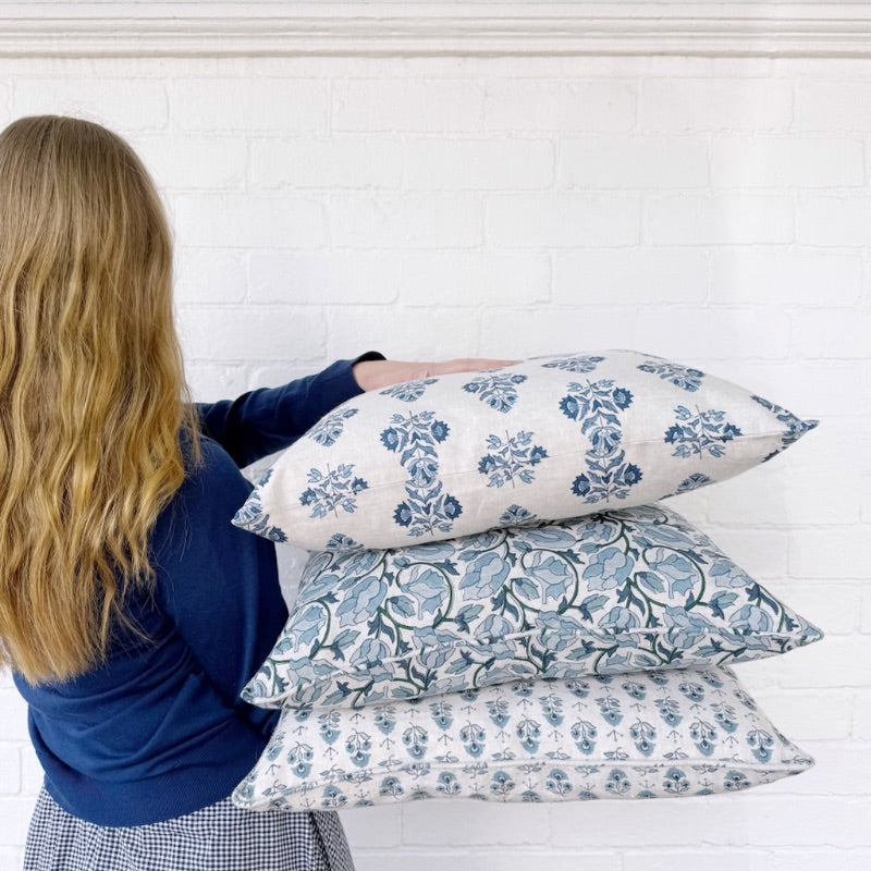 Woman holding a stack of block-printed cushions