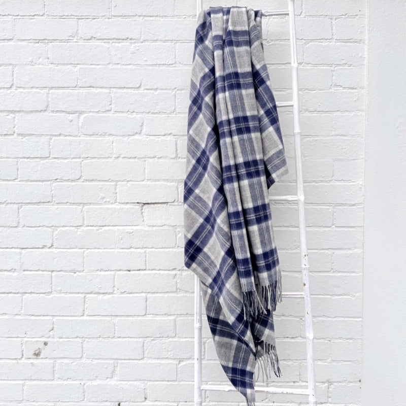 Blue tartan blanket draped over a white ladder