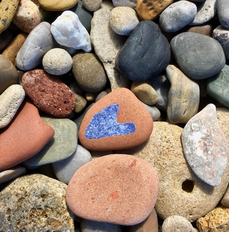 Softly worn pebbles with a tiny heart-shaped flash of blue