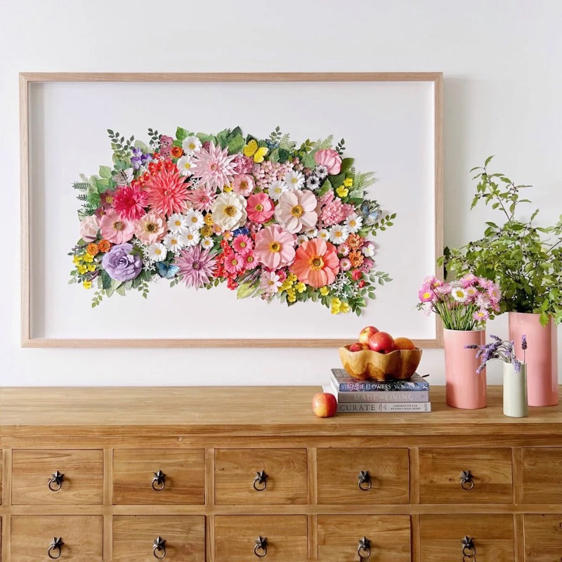 Colourful Mondocherry botanical paper artwork above a wooden dresser