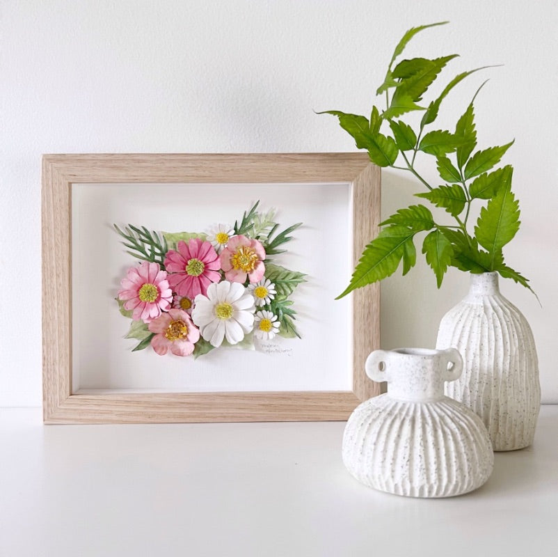 Colourful Mondocherry paper flower artwork above a wooden dresser