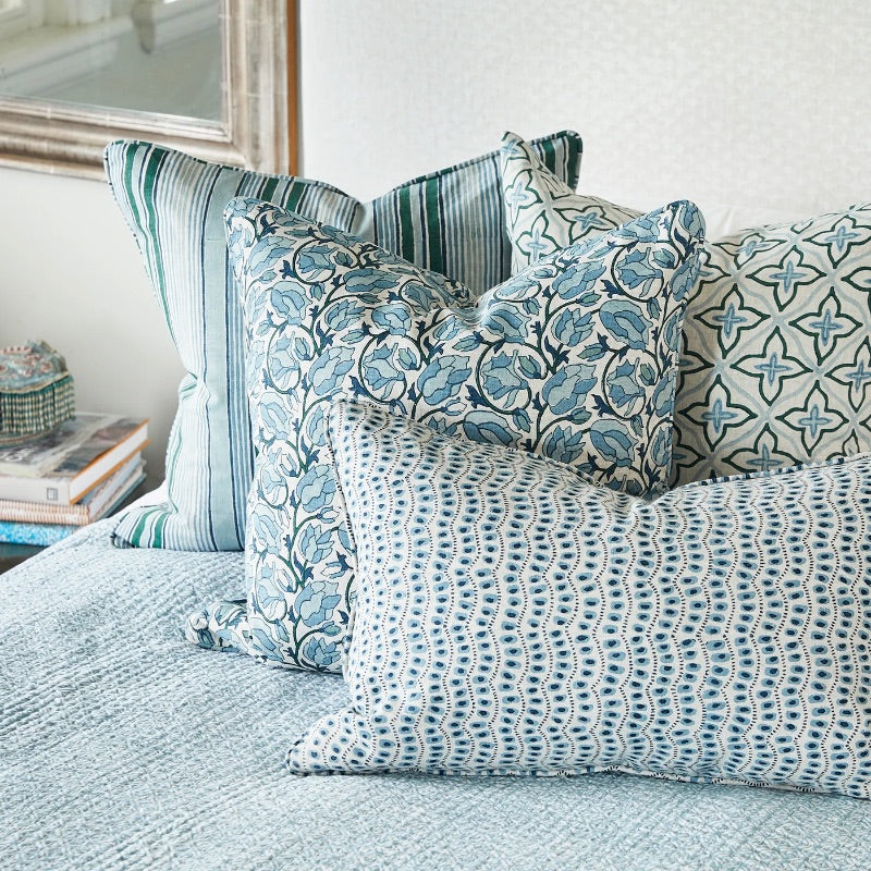Assorted blue patterned Walter G cushions on a bed