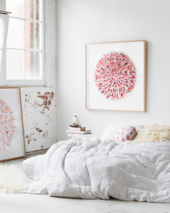 Bedroom with white bed and pink Mondocherry paper feather artwork
