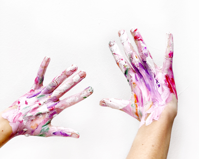 Hands covered in vibrant pink paint