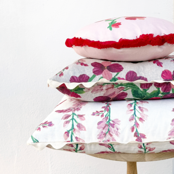 Stack of Bonnie and Neil floral cushions on a stool