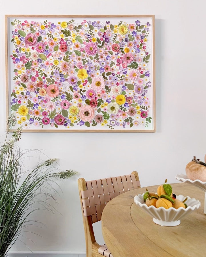 Mondocherry paper flower artwork above a dining table with felt fruit