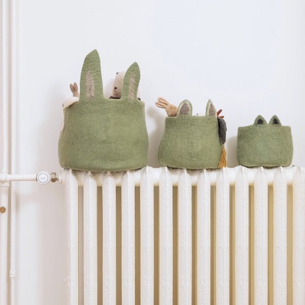 Green felt baskets on a white radiator.