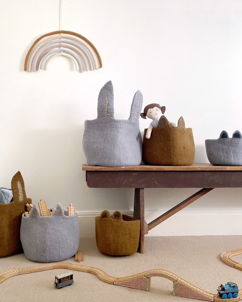 Soft baskets and toys under rainbow decor.