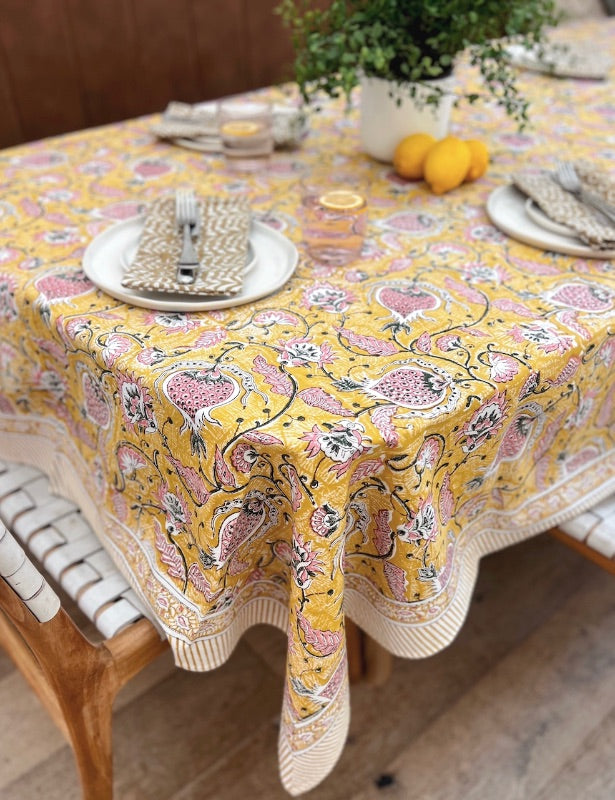 Elegant table with floral yellow tablecloth.