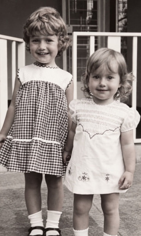 Clare and Joy as young girls holding hands.