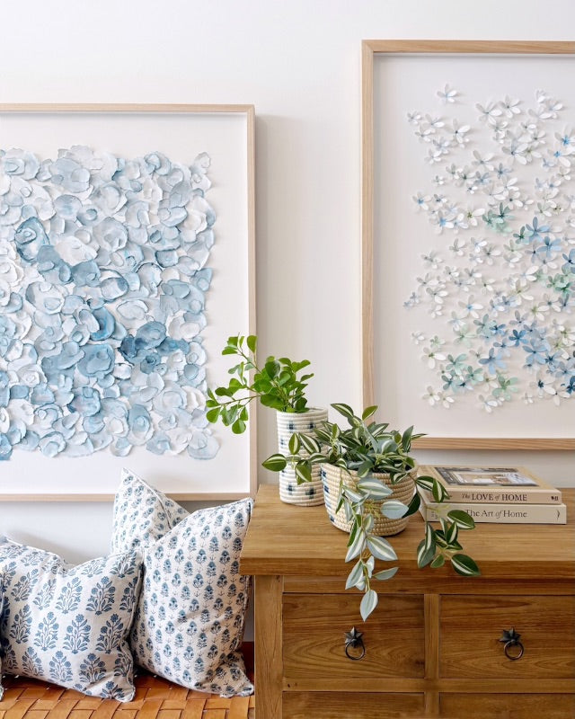 Mondocherry blue artworks, plants, wooden table and blue cushions.