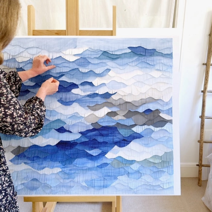 Mondocherry blue paper waves artwork on an easel.