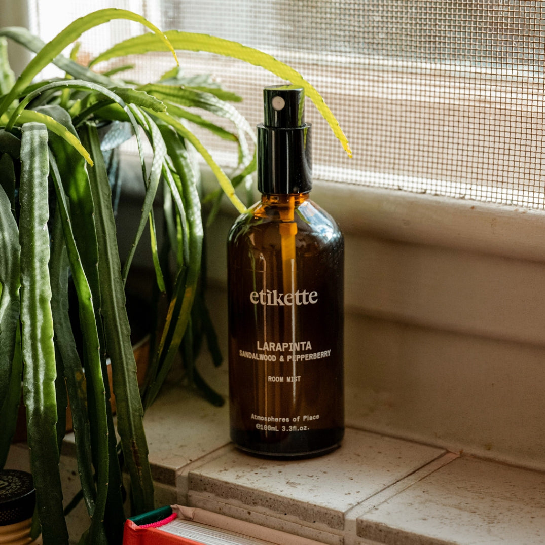 Etikette — room mist — Larapinta in sandalwood & pepperberry — bottle beside a window