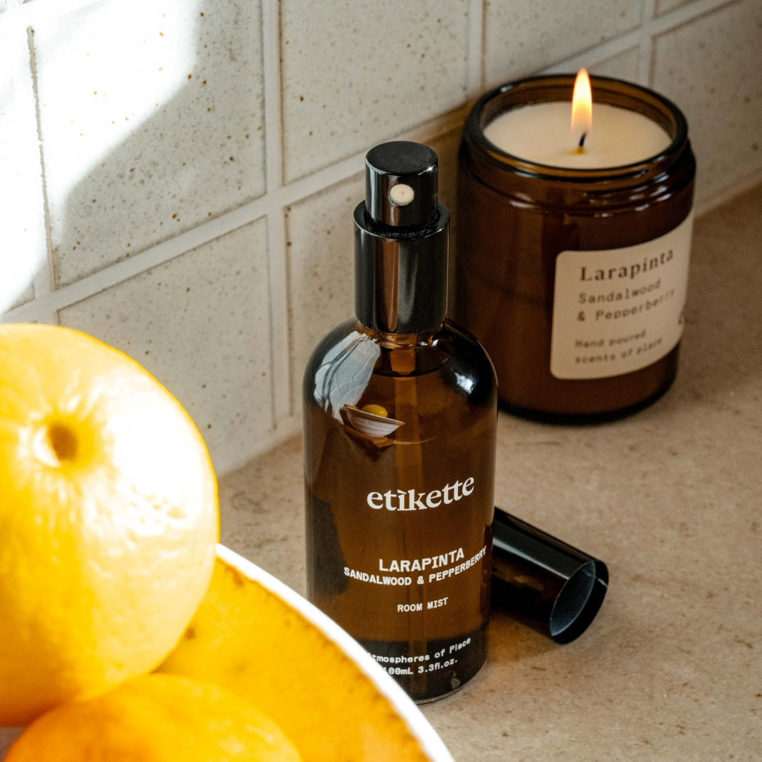 Etikette — room mist — Larapinta in sandalwood & pepperberry — bottle beside a candle