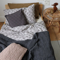 Camomile London | diamond single cotton blanket | charcoal - on bed