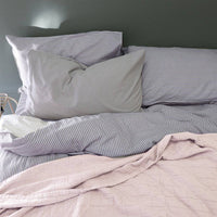 Camomile London | diamond single cotton blanket | pearl pink - in bed